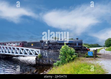 FORT WILLIAM SCOTLAND JACOBITE DAMPFEISENBAHN, DIE ÜBER DEN CALEDONIAN CANAL AUF DER BANAVIE METAL SWING BRIDGE FÄHRT Stockfoto