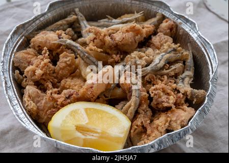 Spanische Meeresfrüchte, knusprig frittierte Babykraken, Fisch, Calamari-Ringe mit Zitrone serviert, Nahaufnahme Stockfoto