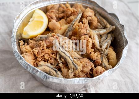 Spanische Meeresfrüchte, knusprig frittierte Babykraken, Fisch, Calamari-Ringe mit Zitrone serviert, Nahaufnahme Stockfoto