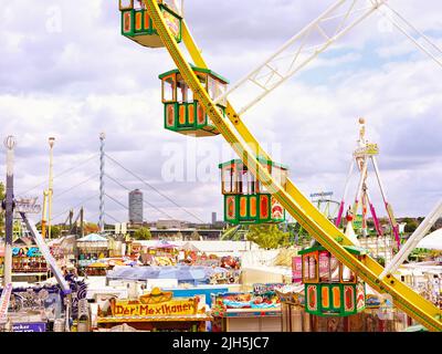 Panoramablick mit Riesenrad auf die beliebte Rheinkirmes 2022 in Düsseldorf, der größten Fun-Messe am Rhein. Stockfoto