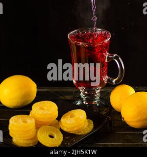 Kreatives Layout aus einer Tasse Hibiskustee und Zitrone auf weißem Hintergrund. Draufsicht. Stockfoto