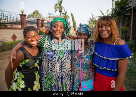 Mehrere Generationen von afrikanischen Freundinnen umarmen und lachen zusammen, afrikanische Frauen Stockfoto