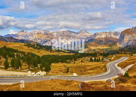 Blick auf kurvenreichen Straße. Asphaltierte Straßen in den italienischen Alpen in Südtirol, im Herbst Saison. Herbst Szene mit gekrümmten Straßen- und gelbe Lärchen aus Bo Stockfoto