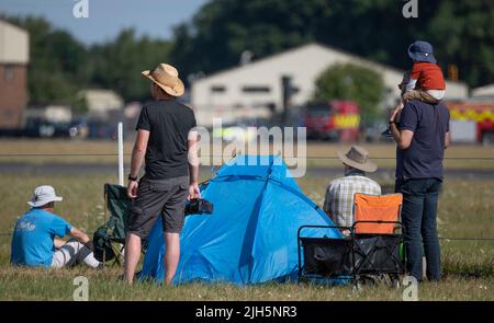 RAF Fairford, Gloucester, Großbritannien. 15. Juli 2022. Unter der heißen Sonne versammeln sich mehrere hundert Militärflugzeuge aller Formen und Größen aus allen Epochen und Ländern der Welt zu einer der größten Airshows der Welt, zu der auch ein besonderes Fest anlässlich des 75.-jährigen Jubiläums der US Air Force gehört. Bild: Plane Spotter und Besucher versuchen sich kühl zu halten. Quelle: Malcolm Park/Alamy Live News Stockfoto