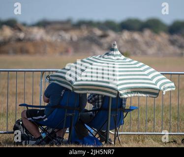 RAF Fairford, Gloucester, Großbritannien. 15. Juli 2022. Unter der heißen Sonne versammeln sich mehrere hundert Militärflugzeuge aller Formen und Größen aus allen Epochen und Ländern der Welt zu einer der größten Airshows der Welt, zu der auch ein besonderes Fest anlässlich des 75.-jährigen Jubiläums der US Air Force gehört. Bild: Plane Spotter und Besucher versuchen sich kühl zu halten. Quelle: Malcolm Park/Alamy Live News Stockfoto