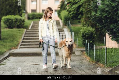 Mädchen mit goldenem Retriever Hund an regnerischen Tagen Stockfoto