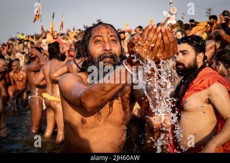 Ein Hindu-Gläubiger, der beim Kumbh Mela-Festival in Allahabad, Indien, betet und im heiligen Ganges-Fluss mit Tausenden von anderen Anhängern badet. Stockfoto