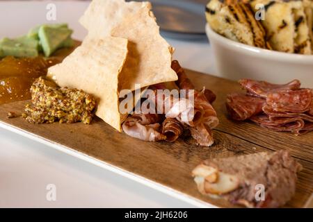 Charcuterie Board mit selektivem Fokus enthält Fleisch, Käse, Chutney und Senf Stockfoto