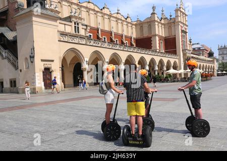 Krakau. Krakau. Polen. Gruppe von Touristen auf Segways mit Führer vor der Sukiennice Tuchhalle in der Mitte des Hauptmarktplatzes, Zentrum des t Stockfoto