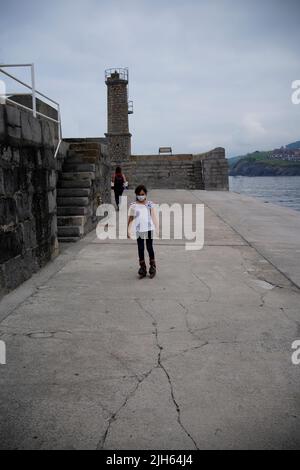 Mädchen skaten mit Inline-Skates mit Frau zu Fuß im Hintergrund Stockfoto