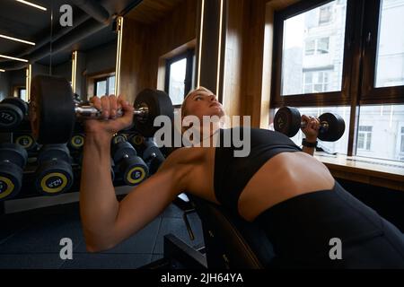 Weibliche Bodybuilder Durchführung von Übungen mit Handgewichten Stockfoto