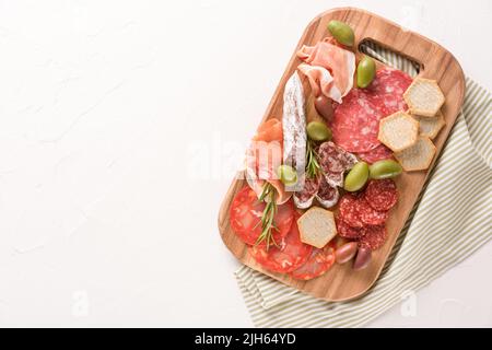 Charcuterie-Tafel mit Wurstsorten - Salami, Bresaola, Proscuitto, serviert mit Oliven und Crackern. Hintergrund des Bannermenüs mit Kopierbereich. Tra Stockfoto