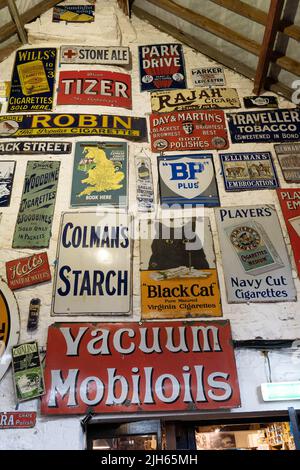 Sammlung von britischen Vintage-Werbeschildern auf weiß getünchten Wänden Stockfoto