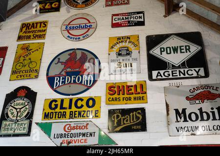 Sammlung von Werbeschildern für Vintage-Motoren auf weißer Wand Stockfoto