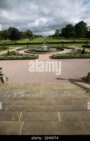 Dumfries House, Cumnock, Schottland, Großbritannien, mit kürzlich installiertem Brunnen an der Vorderseite des Hauses. Der Brunnen, der als Mahfouz-Brunnen bekannt ist. Eine Pest in der Nähe sagt: „Ermöglicht durch die Großzügigkeit von HE Mahfouz Marei Murbank bin Mahfouz. Der Brunnen wurde formell von S.R.H Prinz Charles, Herzog von Rothesay, geöffnet 21. Oktober 2014. Dumfries House ist ein palladianisches Landhaus in Ayrshire, Schottland. Es liegt in einem großen Anwesen, etwa zwei Meilen westlich von Cumnock. Der Brunnen soll im Zentrum eines Skandals um „Cash for Honours“ stehen, bei dem es um die Fürstenstiftung und eine Spende geht Stockfoto