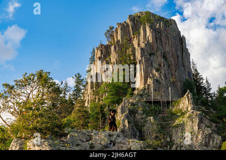 Hohe felsige wilde Gebirgskette der Rhodopen Berge bedeckt mit grüner heller Vegetation, vor dem Hintergrund des Gebirgstals bedeckt mit dichtem d Stockfoto