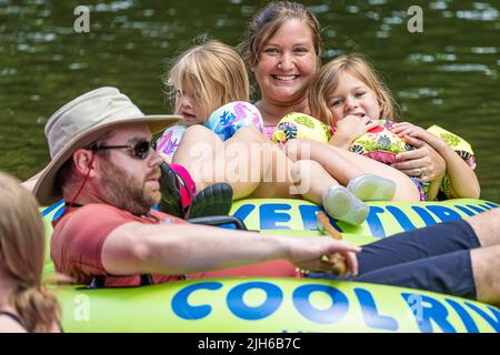 Die Familie genießt eine gemeinsame Tubing-Reise auf dem Chattahoochee River durch Helen, Georgia, in den Northeast Georgia Mountains. (USA) Stockfoto