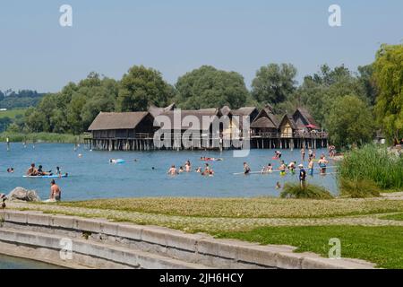 Badegäste im Bodensee vor den Pfahlbauten in Unteruhldingen, Freilichtmuseum, Uhldingen-Mühlhofen, Bodensee Stockfoto