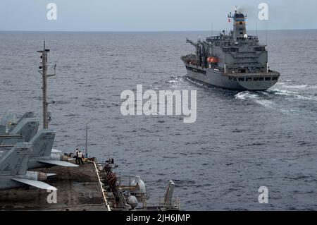 220714-N-SI601-1048 SÜDCHINESISCHES MEER (14. Juli 2022) der einzige vorwärts eingesetzte Flugzeugträger der US-Marine USS Ronald Reagan (CVN 76) nähert sich dem Militär-Sealift-Kommando-Flottennachfüller USNS Yukon (T-AO 202), um eine Auffüllung auf See durchzuführen. Während der Entwicklung transportierte Yukon Fracht und Treibstoff über eine angeschlossene Nachfüllung zu Ronald Reagan. Ronald Reagan, das Flaggschiff der Carrier Strike Group 5, stellt eine kampfbereite Kraft zur Verfügung, die die Vereinigten Staaten schützt und verteidigt und Allianzen, Partnerschaften und kollektive maritime Interessen in der Indo-Pazifik-Region unterstützt. (USA Navy ph Stockfoto