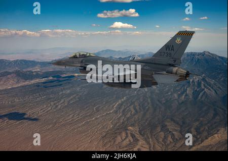 Eine F-16 Fighting Falcon, die von Kapitän Tim „REEF“ Joubert, dem Instruktor-Piloten der 64. Aggressor Squadron, gesteuert wird, fliegt über die Nevada Test- und Trainingsspanne, nachdem sie an einer Red Flag-Nellis 22-3 Mission auf der Nellis Air Force Base, 12. Juli 2022, teilgenommen hat. Die Nevada Test and Training Range ist das wichtigste militärische Trainingsgebiet der US Air Force mit mehr als 12.000 Quadratmeilen Luftraum und 2,9 Millionen Hektar Land. (USA Luftwaffe Foto von Senior Airman Zachary Rufus) Stockfoto