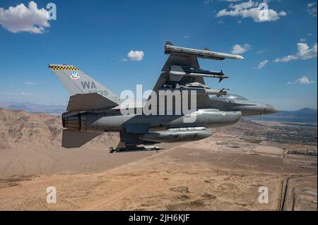 Eine F-16 Fighting Falcon, die von Kapitän Tim „REEF“ Joubert, dem Instruktor-Piloten der 64. Aggressor Squadron, gesteuert wird, fliegt über North Las Vegas, nachdem sie an einer Red Flag-Nellis 22-3 Mission auf der Nellis Air Force Base, 12. Juli 2022, teilgenommen hat. Während RF-N 22-3 verfeinert die Aggressor-Nation die Bedrohungsreplikation, wendet erweiterte Bedrohungen und Störfunktionen an und erhöht die Bedrohungsfunktionen, um die Schulung in nicht-freizügigen Umgebungen zu maximieren. (USA Luftwaffe Foto von Senior Airman Zachary Rufus) Stockfoto