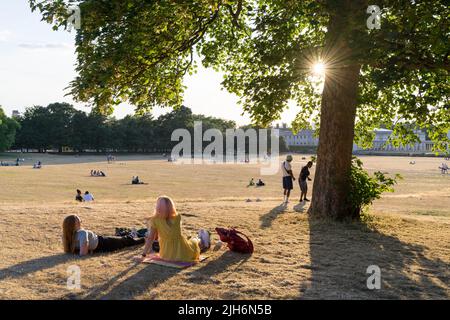 London, 15.. Juli 2022. Wetter in Großbritannien. Die Öffentlichkeit zieht sich in den Greenwich Park, um den heißen Sommer freitagnachmittag zu genießen, da Sonnenstrahlen das Gras im Park austrocknen, ein nationaler Notfall in Großbritannien wurde ausgerufen, nachdem zum ersten Mal eine rote extreme Hitzewarnung ausgegeben wurde, da die Temperaturen am kommenden Montag 40C Grad erreichen könnten. London, England. Quelle: Xiu Bao/Alamy Live News Stockfoto