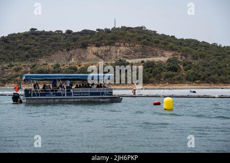 In der Nähe des schwimmenden Solarkraftwerks in Alqueva ist ein Boot mit Gästen zu sehen. Die am 15.. Juli eingeweihte Anlage ist bereit, mehr als 30 % der Bevölkerung der Regionen Moura und Portel im Süden Portugals mit Energie zu versorgen. Das 4 schwimmende Solarkraftwerk befindet sich am Alqueva-Staudamm und verfügt über eine installierte Leistung von 5 MW und eine Kapazität von rund 12.000 7,5 GWh pro Jahr.die Anlage ist die größte in Europa, an einem Stausee. (Foto von Hugo Amaral/SOPA Images/Sipa USA) Stockfoto