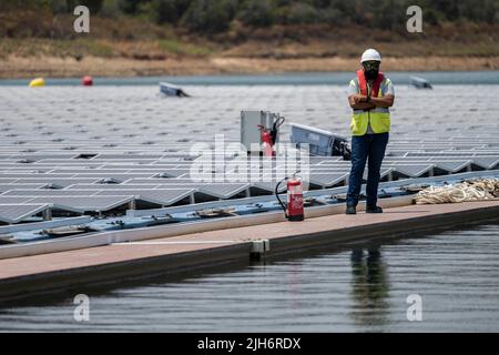 Alqueva, Portugal. 15.. Juli 2022. Alqueva, Alentejo, Portugal. 15.. Juli 2022. Ein Mitarbeiter wurde im schwimmenden Solarkraftwerk in Alqueva gesehen. Die am 15.. Juli eingeweihte Anlage ist bereit, mehr als 30 % der Bevölkerung der Regionen Moura und Portel im Süden Portugals mit Energie zu versorgen. Das schwimmende Solarkraftwerk befindet sich am Alqueva-Staudamm und verfügt über eine installierte Leistung von 5 MW und eine Kapazität von rund 7,5 GWh pro Jahr.die Anlage ist mit einer Fläche von knapp toÂ 12.000 Photovoltaikanlagen auf einer Fläche von 4 Hektar die größte in Europa an einem Stausee. (Bild: © Hugo Amaral/SOPA Stockfoto