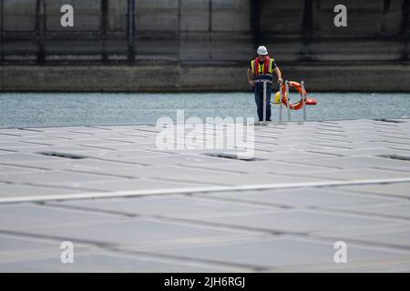 Alqueva, Portugal. 15.. Juli 2022. Alqueva, Alentejo, Portugal. 15.. Juli 2022. Ein Mitarbeiter wurde im schwimmenden Solarkraftwerk in Alqueva gesehen. Die am 15.. Juli eingeweihte Anlage ist bereit, mehr als 30 % der Bevölkerung der Regionen Moura und Portel im Süden Portugals mit Energie zu versorgen. Das schwimmende Solarkraftwerk befindet sich am Alqueva-Staudamm und verfügt über eine installierte Leistung von 5 MW und eine Kapazität von rund 7,5 GWh pro Jahr.die Anlage ist mit einer Fläche von knapp toÂ 12.000 Photovoltaikanlagen auf einer Fläche von 4 Hektar die größte in Europa an einem Stausee. (Bild: © Hugo Amaral/SOPA Stockfoto