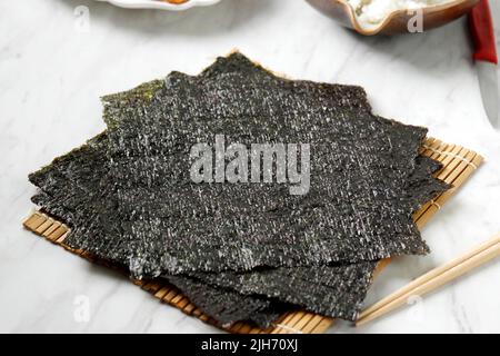 Japanisch getrocknete Nori Laver geröstete Algen für Sushi oder Kimbap, auf weißem Tisch Stockfoto