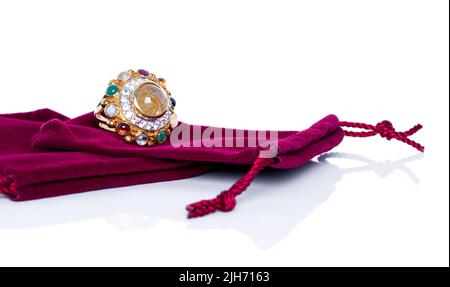 Goldener Rutilierter Quarz und Diamanten mit neun Edelsteinen auf rotem Samtbeutel. Kollektion von natürlichen Edelsteinen Accessoires. Studioaufnahme Stockfoto