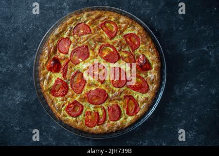 Köstliche vegetarische Zucchini-Pie mit roten Tomaten, Draufsicht, Nahaufnahme. Geriebene Zucchini mit Eiern, Mehl und Sauerrahm, und all das in der Ove gebacken Stockfoto