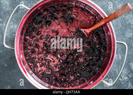 Zubereitung von frisch gepflückten roten Kirschen mit Zucker zur Kirschmarmelade, Nahaufnahme, Draufsicht Stockfoto