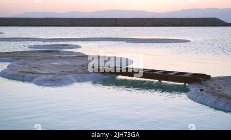Die Leiter, die zwischen zwei Inseln des Salzes beim Toten Meer gelegt ist. Spaß am Meer Stockfoto