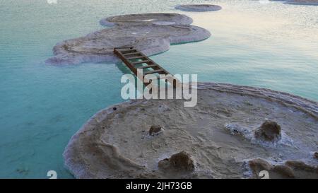 Die Leiter, die zwischen zwei Inseln des Salzes beim Toten Meer gelegt ist. Spaß am Meer Stockfoto