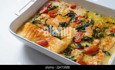 Lachsfilet mit Spinat und Kirschtomaten in cremiger Sauce Stockfoto