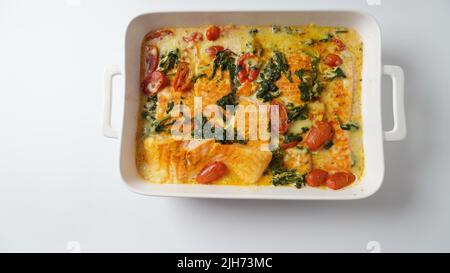 Lachsfilet mit Spinat und Kirschtomaten in cremiger Sauce Stockfoto