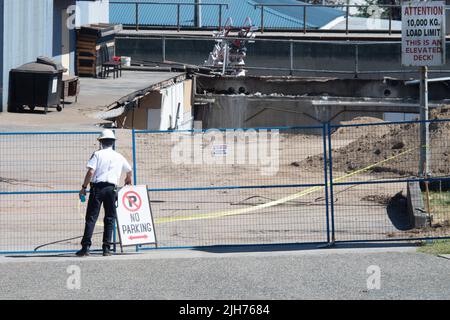 14. Juli 2022, Vancouver, British Columbia, Kanada: Ein Feuerwehrbeamter in Vancouver, B.C. schließt den Standort, an dem am 14. Juli ein Dachparkldeck auf einen Bürobereich darunter einstürzte. Rettungsmannschaften arbeiteten mehr als 36 Stunden auf der Suche nach einer Person, die als vermisst gemeldet wurde, und die von der Familie in den lokalen Medien als Ben Sotelo identifiziert wurde. Gegen 10:30 Uhr am nächsten Tag sagte die Polizei, dass ein Leichnam von der Anlage geborgen wurde. Nach Angaben der Feuerwehr stürzte das Deck unter dem Gewicht eines Laders ein und schuf ein Loch in einer Höhe von neun mal 12 Metern. Acht Personen, darunter der Fahrer des Laders, wurden aus dem Gebäude gerettet. (Bild: Stockfoto