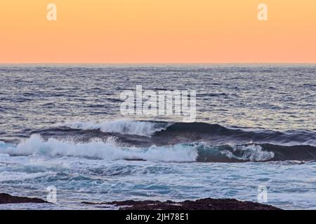 Die Wellen brechen im Morgengrauen im südlichen Indischen Ozean, an der Küste der Garden Route, Südafrika Stockfoto