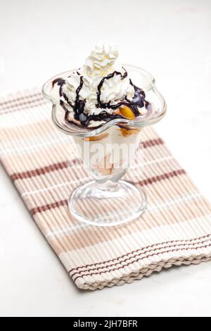 Eis mit geschmorten Pfirsich und Schlagsahne Stockfoto