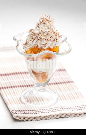 Eis mit geschmorten Pfirsich und Schlagsahne Stockfoto