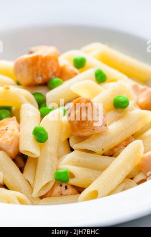 Pasta Penne mit Lachs und grünen Erbsen Stockfoto