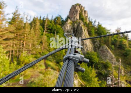 Zuverlässiges, starkes Metallkabel mit Verbindungsbefestigung mit Schrauben und Muttern verschiedener Größen, im Freien Stockfoto