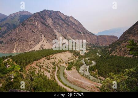 Seton Lake Lookout in Lillooet, B.C. die Aussicht auf die rechte Seite des Berges und den türkisfarbenen Fluss. Trübe Himmel. Stockfoto