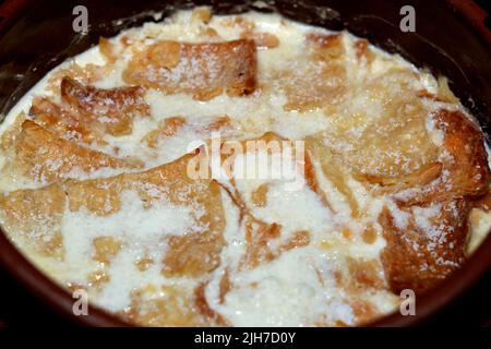 Traditionelle arabische ägyptische östliche Dessertküche namens Om Ali, ägyptisches Brot Pudding in einer braunen Schüssel Töpfereiauflauf aus Milch, ägyptische bre Stockfoto