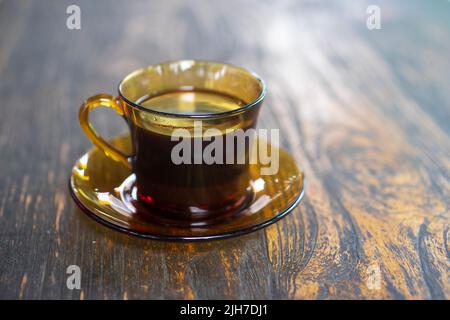 Eine Tasse indonesischer schwarzer java-Kaffee auf einem Holztisch mit hellem Hintergrund Stockfoto