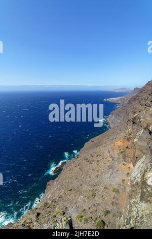 Erhöhter Blick auf das Meer von einer Klippe. Weiter Horizont zwischen dem Meer und dem blauen Himmel. Stockfoto