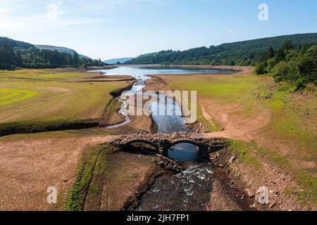 MERTHYR TYDFIL, WALES - JULI 16: Luftaufnahme einer freigelegten Brücke, die normalerweise unter Wasser im Llwyn-on Reservoir, dem größten der drei Stauseen, liegt Stockfoto