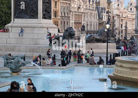 LONDON, GROSSBRITANNIEN - 7. SEPTEMBER 2014: Nicht identifizierte Menschen ruhen sich an einem Herbstabend am Fuße der Nelson-Säule auf dem Trafalgar Square aus. Stockfoto