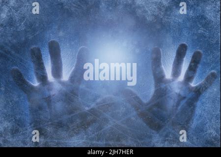 Menschliche Hände gegen gefrorenes Glas und blauen Hintergrund. Getöntes Bild. Energiekrisenkonzept. Kalter Winter 2022 Stockfoto